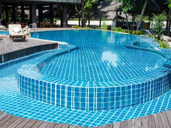 Piscina de agua salada con gresite azul en un complejo residencial de la Costa del Sol